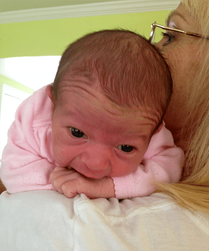 A baby is laying on the chest of its mother.