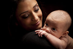 A woman holding a baby in her arms.