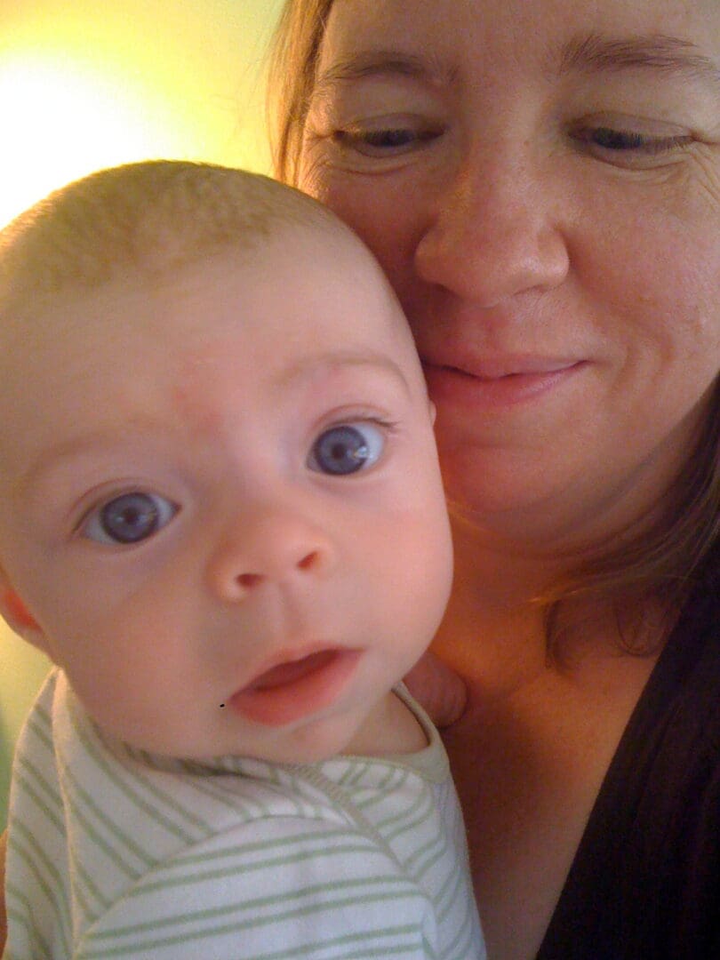 A woman holding a baby in her arms.