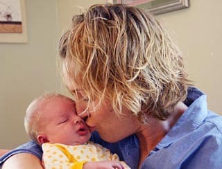 A woman holding a baby in her arms.